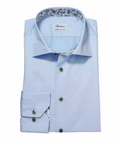 Ljusblå skjorta med blommönstrad kontrast och extra långa ärmar. 